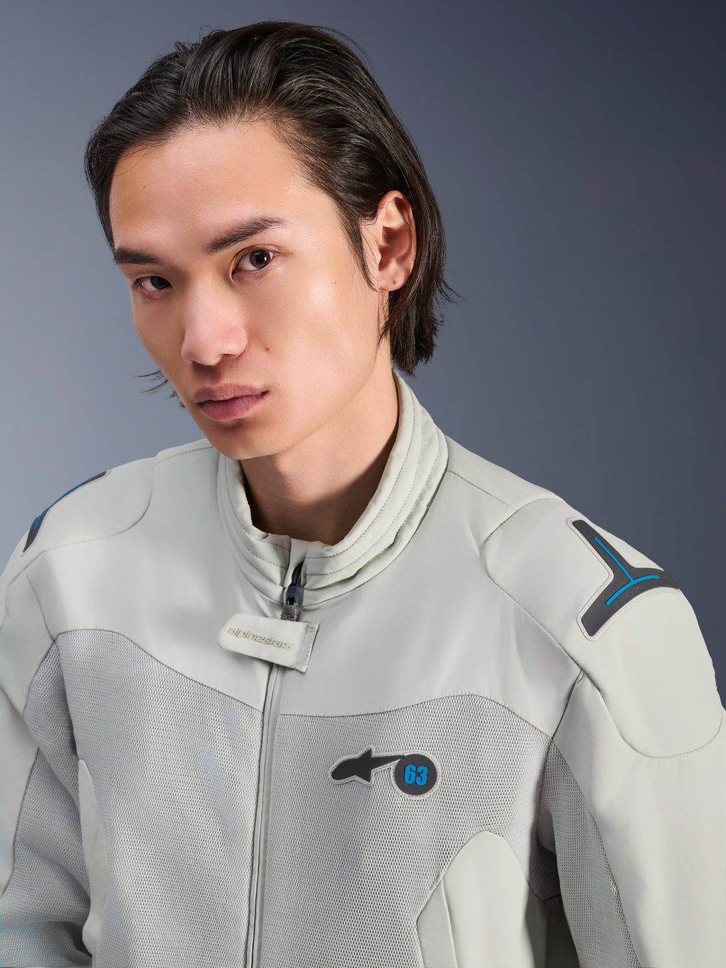 Veste Alpinestars Circal-1 Air, gris métal avec accents bleu méthyle, mannequin homme portant une veste de moto urbaine d'été, gros plan sur les panneaux de ventilation en maille et le logo minimaliste sur la poitrine