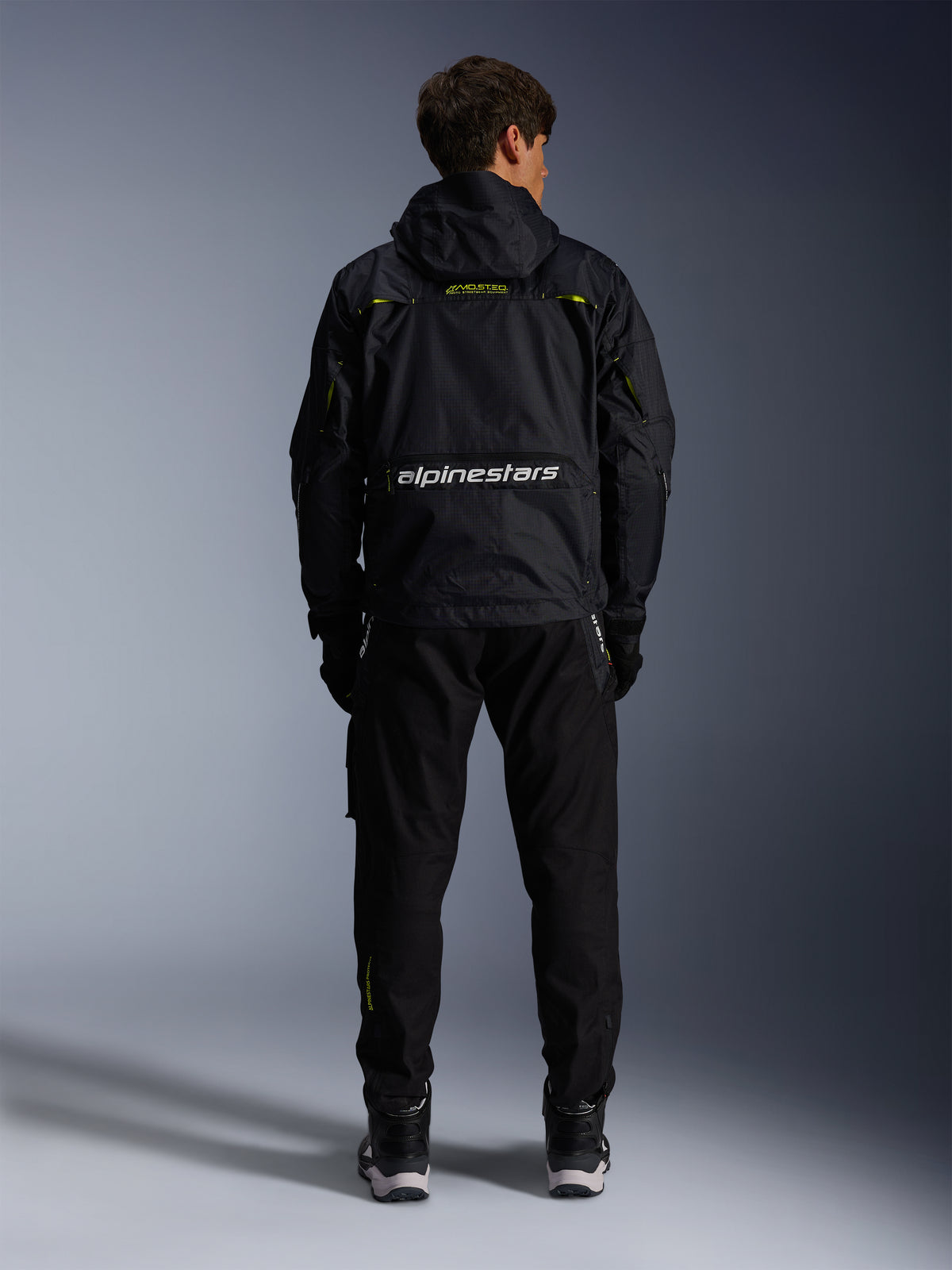 Veste Alpinestars Mogress Air, blouson de moto urbain pour homme, noir avec détails lime punch, vue de dos montrant le logo blanc et la construction en textile ripstop.