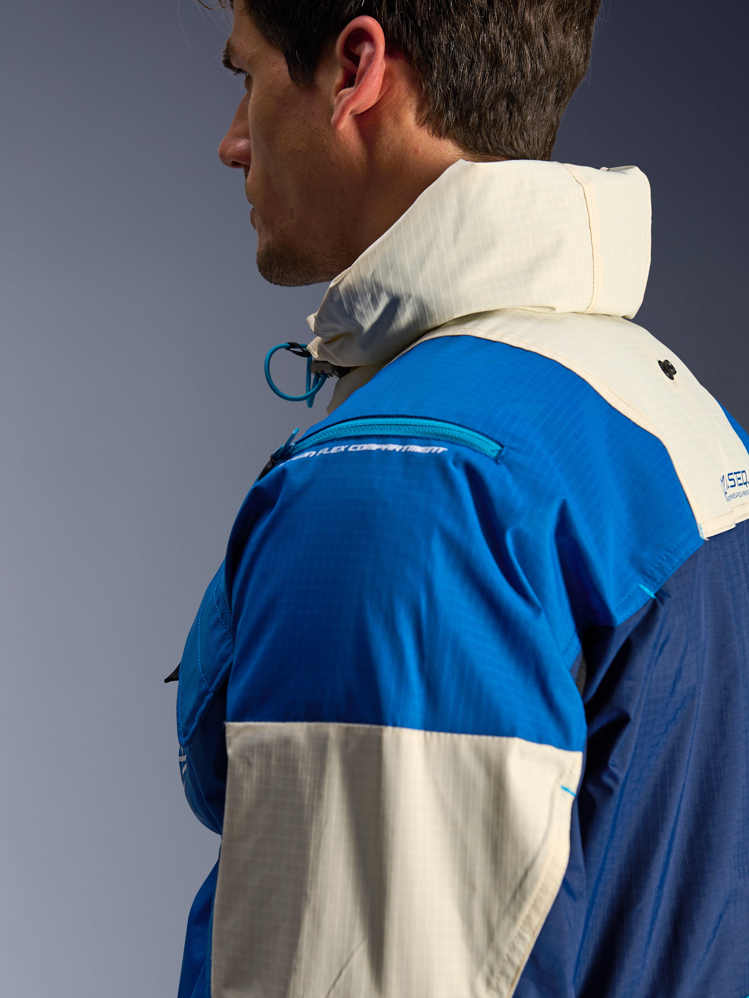 Veste Alpinestars Mogress Air en Blue Almond, gros plan de profil, avec tissu ripstop en nylon recyclé, compartiment zippé pour protection d'épaule, col montant avec capuche intégrée, vêtement de moto urbain contemporain style streetwear