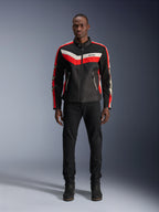 Veste Alpinestars T-Dyno Air, veste de moto en textile, noir, rouge vif et écru, portée par un mannequin avec un pantalon et des bottes noirs, dotée d'un design d'inspiration vintage avec des bandes de couleurs vives sur la poitrine, des logos étoiles sur les manches et une construction en maille respirante pour la conduite urbaine.