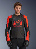 Alpinestars T-Stunt Air Jacket, veste de moto en textile, noir, rouge fluo et rouge foncé, avec un grand logo étoile et des panneaux en maille pour la circulation de l'air, portée par un mannequin avec des gants noirs