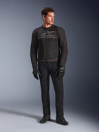 Mannequin homme portant la veste de moto Alpinestars SMX Air, coloris Black Anthracite, avec panneaux en maille ventilée et logo gris sur la poitrine, associée à un pantalon noir et des gants de protection, studio avec fond en dégradé