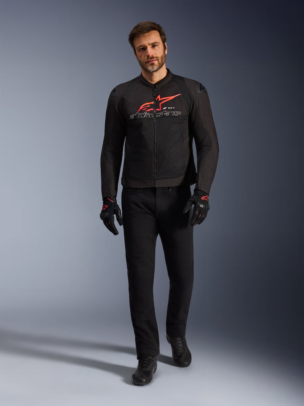 Alpinestars SMX Air Jacket, Black Bright Red and White, sport motorcycle jacket worn with black riding pants and gloves, featuring technical mesh panels and a bold red Alpinestars logo on the chest, performance street riding outfit