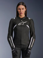 Veste Alpinestars Stella T-Sps Air V2 pour femme, veste de moto en textile, noir et blanc, dotée de panneaux en mesh technique perforés et du logo Alpinestars blanc, portée par un mannequin avec des gants noirs, conçue pour la conduite sur route ventilée en été