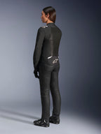 Veste Alpinestars Stella T-Sps Air V2, noir et blanc, vue de dos montrant les panneaux en mesh et le logo sur le bas du dos, associée à un pantalon de moto noir et des chaussures de moto, équipement de route sportif en textile pour femme