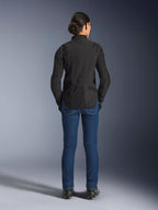 Veste Stella Aeroshell Airflow Alpinestars, Noir Anthracite, vue de dos sur un mannequin, dotée d'un châssis softshell léger avec panneaux en maille perforés au laser, profil arrière allongé pour une meilleure couverture, coupe sport, portée avec un jean bleu