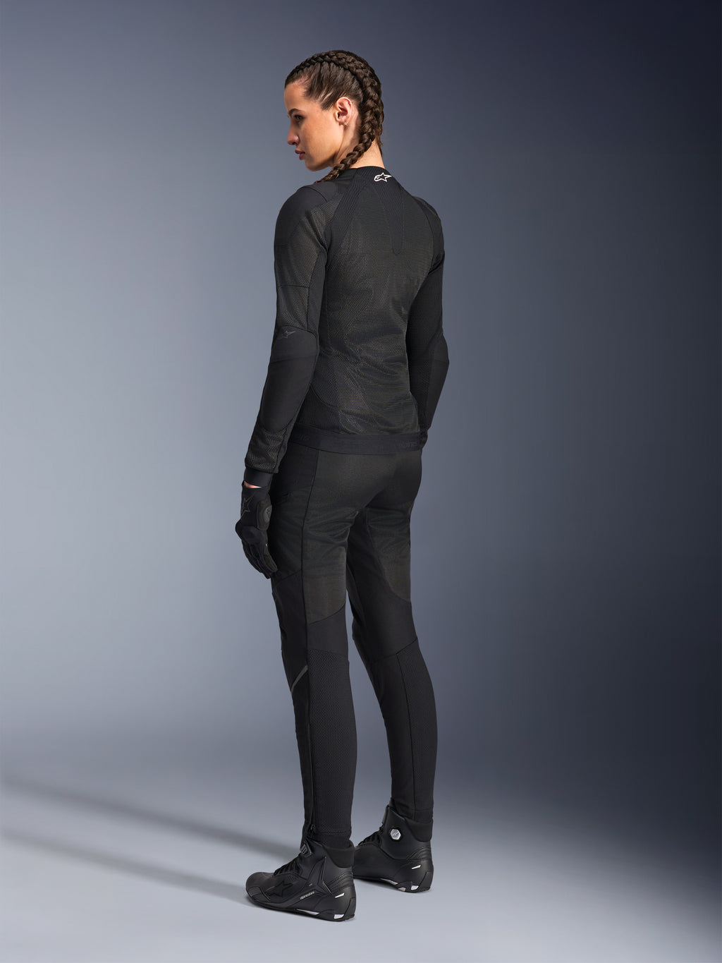 Veste Alpinestars Stella Troop-Air pour femme, noire, vue de dos, portée avec un pantalon de moto, des gants et des bottes noirs assortis, construction technique en maille ajustée pour la conduite urbaine
