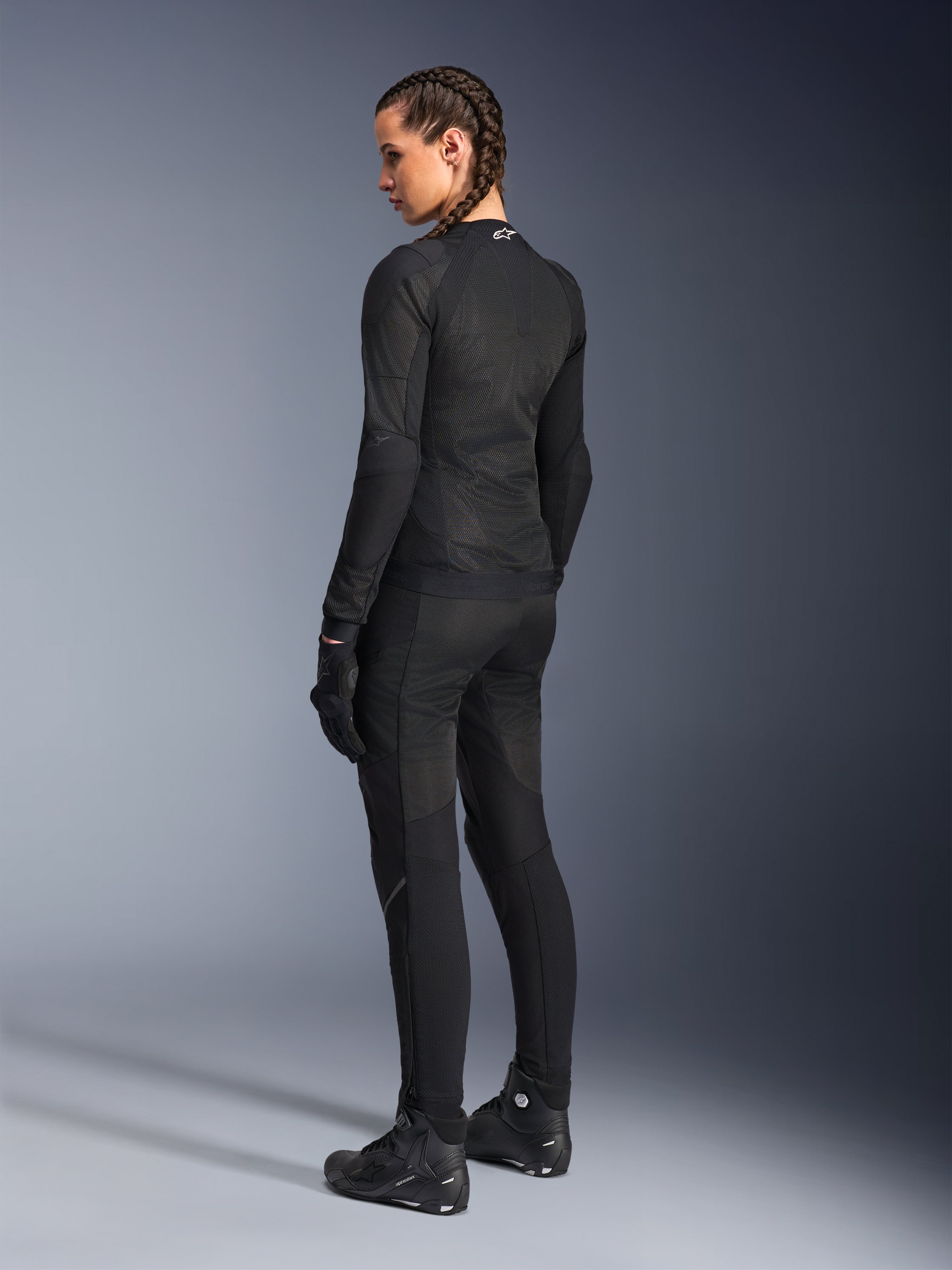 Veste Alpinestars Stella Troop-Air pour femme, noire, vue de dos, portée avec un pantalon de moto, des gants et des bottes noirs assortis, construction technique en maille ajustée pour la conduite urbaine