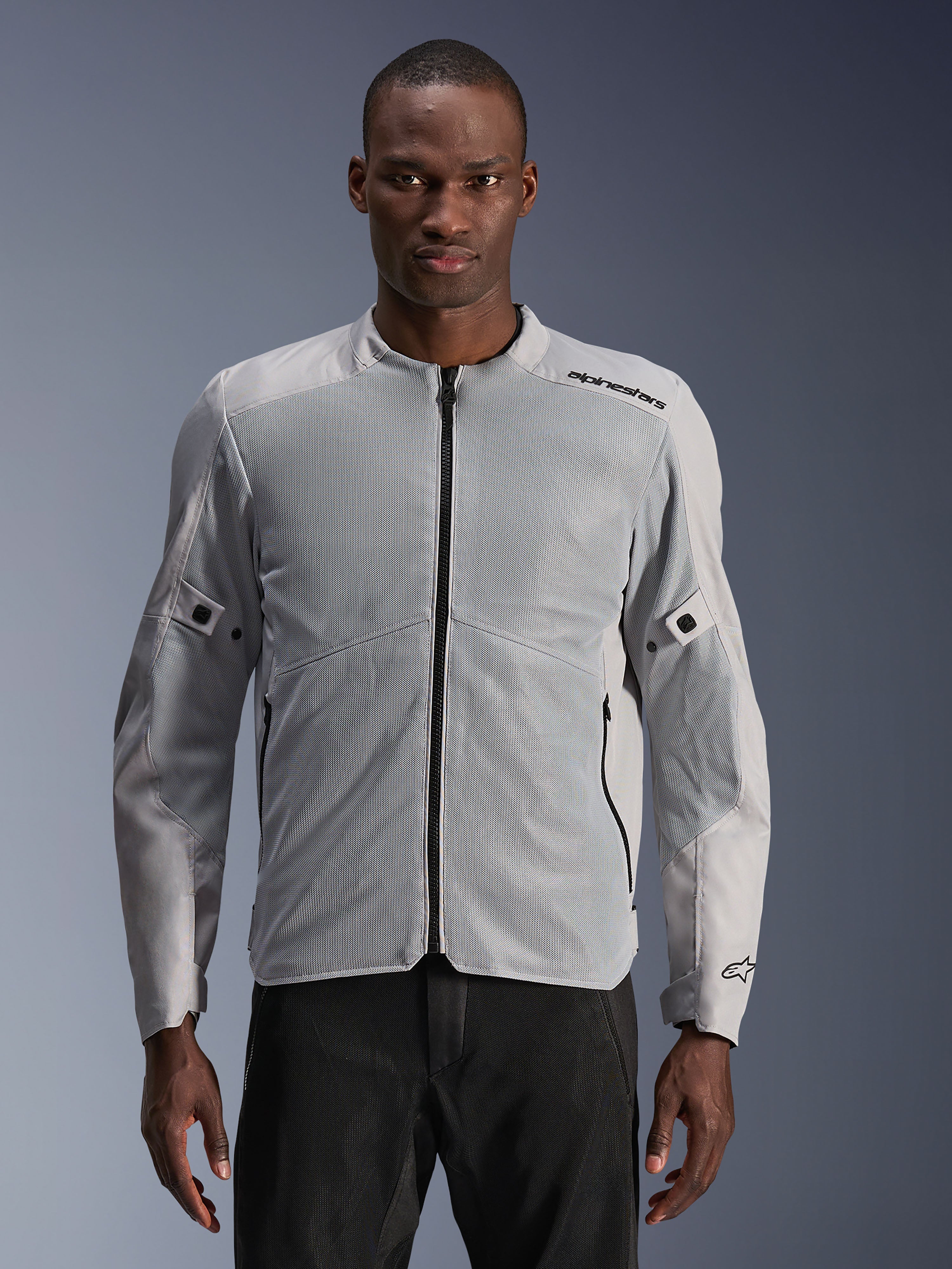 Veste Alpinestars C-1 Air, veste de moto urbaine, argent et gris, dotée de larges panneaux en mesh technique sur la poitrine et les manches, fermeture éclair centrale noire, logo minimaliste sur l'épaule, design léger et ventilé pour les trajets urbains