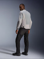 Veste Alpinestars C-1 Air, argent et gris, vue de dos sur un modèle, avec panneaux en maille technique ventilée et logos réfléchissants, portée avec un pantalon et des chaussures noirs, équipement de moto urbain contemporain.