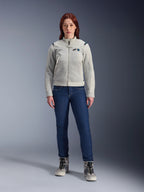 Veste Alpinestars Stella CIRCAL-1 Air, veste de moto pour femme, gris métal et bleu méthyle, portée avec un jean bleu foncé et des bottes de moto grises, dotée de panneaux en mesh pour la ventilation et d'un design urbain moderne