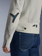 Veste Alpinestars Stella Circal-1 Air pour femme en gris métal et bleu méthyle, gros plan sur les détails du dos et de la manche montrant les panneaux de flux d'air en maille, les accents bleu néon sur le coude et la taille, et la patte de réglage, portée avec un jean en denim bleu foncé.