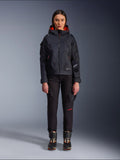 Pantalon femme Alpinestars Actea, pantalon de moto noir avec détails de texte rouges et poches cargo, porté par une motarde avec une veste à capuche noire, tenue de moto urbaine moderne
