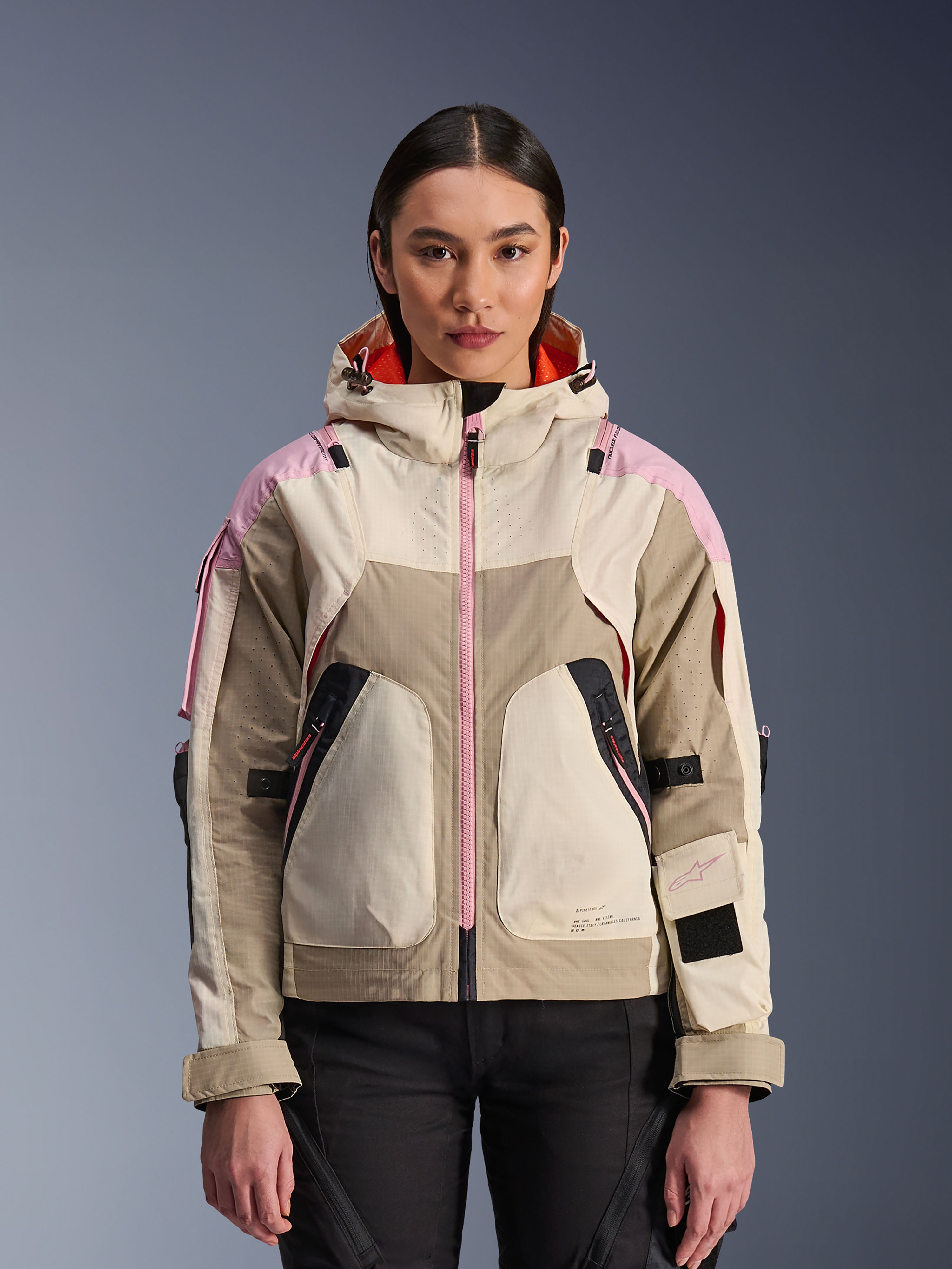 Alpinestars Molly Air Jacket, veste de moto urbaine pour femme, coloris Sand Pink Almond, dotée d'une capuche avec ventilation perforée au laser, d'une fermeture éclair rose et de sangles de manche réglables, présentée sur un modèle.