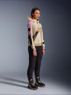 Mannequin femme portant la veste Alpinestars Molly Air en coloris Sand Pink Almond, associée à un pantalon technique sombre et des bottes de moto montantes, veste de moto urbaine avec capuche et empiècements multicolores, design contemporain inspiré du streetwear