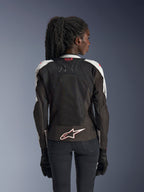 Veste Alpinestars Stella SMX Air, veste de moto pour femme, gris glacé et noir avec accents corail fluo, vue arrière montrant le marquage Tech-Air Ready et le logo Astar blanc, châssis en mesh pour une ventilation élevée, coupe de style sportif