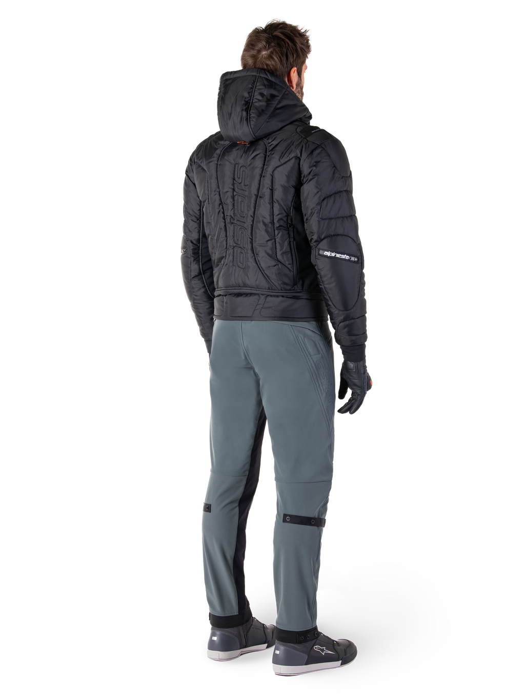 Pantalon Alpinestars Alden, pantalon de moto urbain, Gris Urbain, vue arrière d'un pilote portant une veste à capuche matelassée noire et des baskets de moto, coupe ajustée sous le genou avec panneaux extensibles noirs et ajusteurs aux genoux, design moderne d'inspiration streetwear