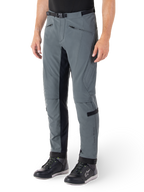 Pantalon Alpinestars Alden, pantalon de moto gris urbain et noir, pantalon de moto en textile inspiré du streetwear avec softshell extensible à 3 couches, empiècements noirs à l'intérieur des jambes, ceinture intégrée, coupe ajustée sous le genou, porté avec des chaussures de moto noires