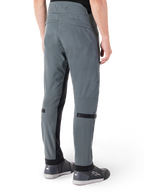 Pantalon Alpinestars Alden, Gris Urbain, vue latérale arrière, pantalon de moto technique d'inspiration streetwear avec détails matelassés à la taille et sangles noires aux mollets, associé à des chaussures de moto grises, équipement de moto urbain moderne