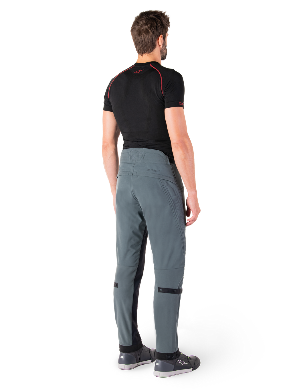 Pantalon Alpinestars Alden, Urban Gray, vue arrière, pantalon de moto en textile technique avec détails matelassés sur le haut de la taille arrière et les jambes, associé à une couche de base noire et des chaussures de moto grises, style streetwear urbain contemporain.