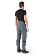 Pantalon Alpinestars Alden, Urban Gray, vue arrière, pantalon de moto en textile technique avec détails matelassés sur le haut de la taille arrière et les jambes, associé à une couche de base noire et des chaussures de moto grises, style streetwear urbain contemporain.