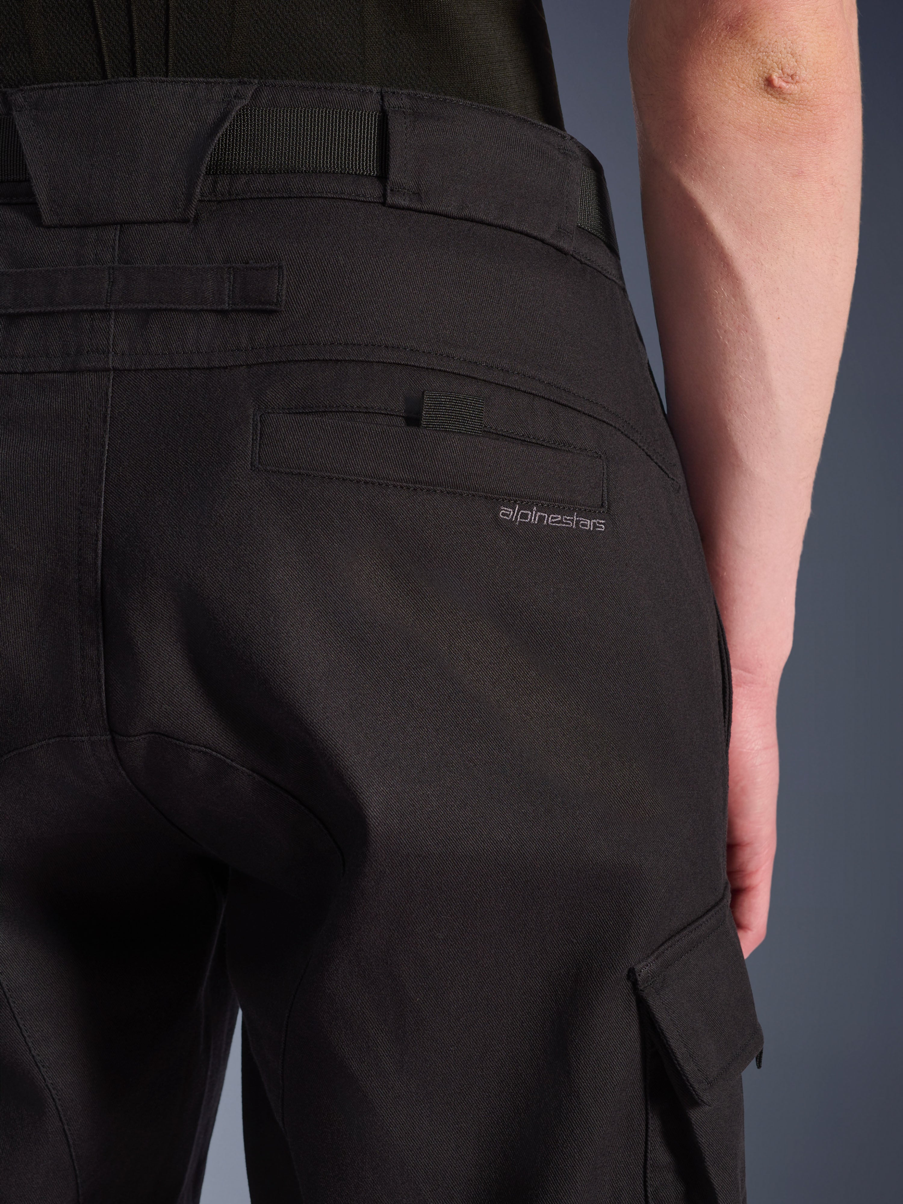 Gros plan sur le pantalon cargo Alpinestars Flex-AST en noir, pantalon de moto urbain doté d'une poche arrière détaillée avec marquage discret, de larges passants de ceinture et d'une poche cargo latérale en textile extensible durable.