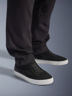 Pantalon Cargo Flex-AST Court Alpinestars, pantalon de moto urbain, noir, avec jambes fuselées et ourlets élastiqués, associé à des baskets Alpinestars noires, style de conduite urbain contemporain