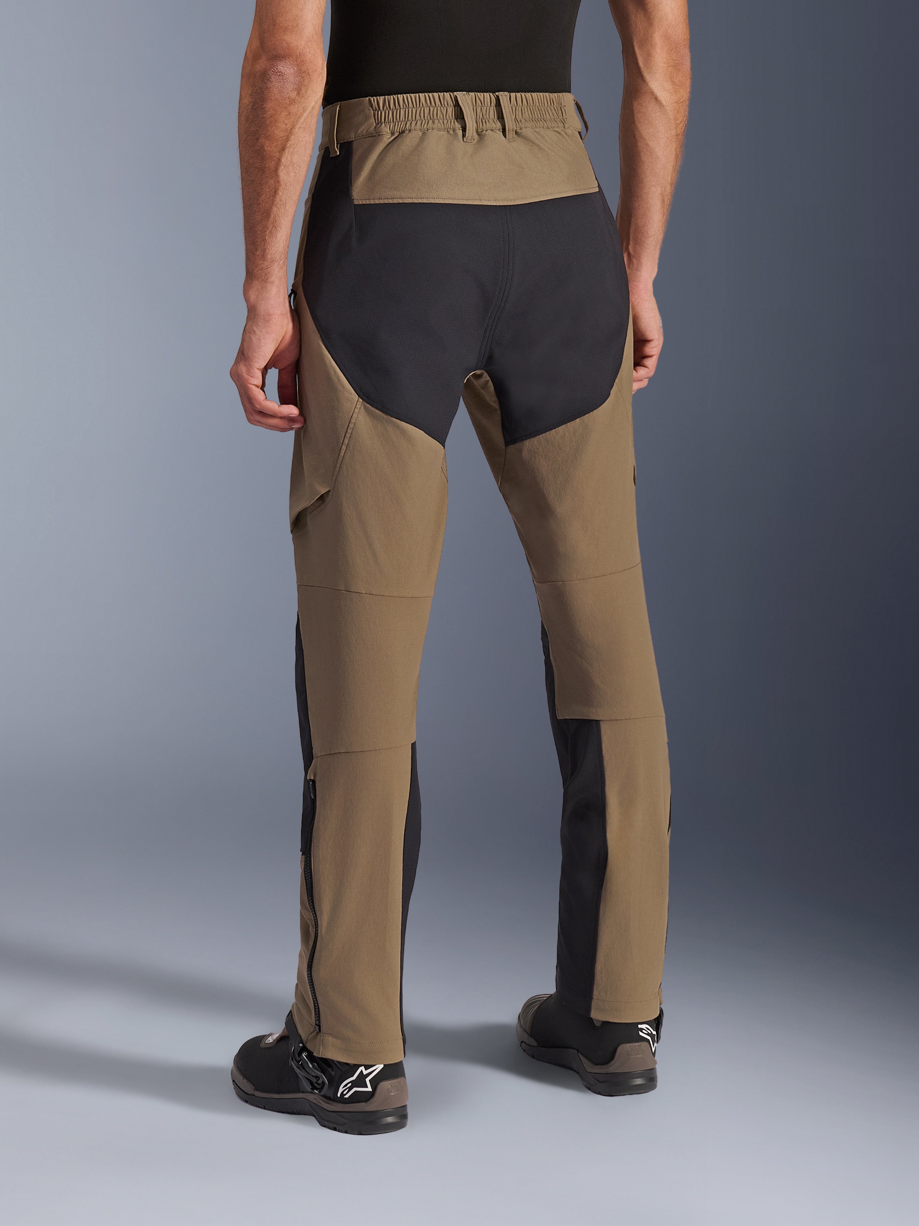 Alpinestars Flex-AST Explorer Pants, pantalon de moto aventure Walnut Black, vue arrière montrant les panneaux ripstop noirs sur l'assise et les jambes, taille élastiquée et construction en textile extensible durable.