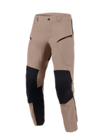 Pantalon Alpinestars Flex-AST Explorer, Walnut Black, pantalon de moto d'aventure doté d'un textile extensible brun avec panneaux de renfort en ripstop noir aux genoux et à l'intérieur des jambes, poches cargo zippées et conception durable pour divers terrains.