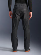 Alpinestars C-1 Air Pants, vue arrière, noir, pantalon de moto urbain en textile doté de larges panneaux en mesh technique à l'arrière des jambes pour la ventilation, design épuré avec logo discret, porté avec une couche de base noire et des chaussures de moto décontractées.