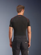 Pantalon Alpinestars Flex-AST Canvas en Black Aluminum, vue arrière sur modèle, pantalon de moto urbain d'inspiration workwear avec logo sur la poche arrière, associé à une couche de base noire à manches courtes avec surpiqûres rouges.