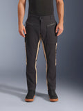 Alpinestars Flex-AST Canvas Pants, pantalon de moto urbain, noir et aluminium, design workwear d'inspiration héritage, poches avant zippées, coupe moto ergonomique, porté avec des baskets noires décontractées et un t-shirt noir, style urbain utilitaire