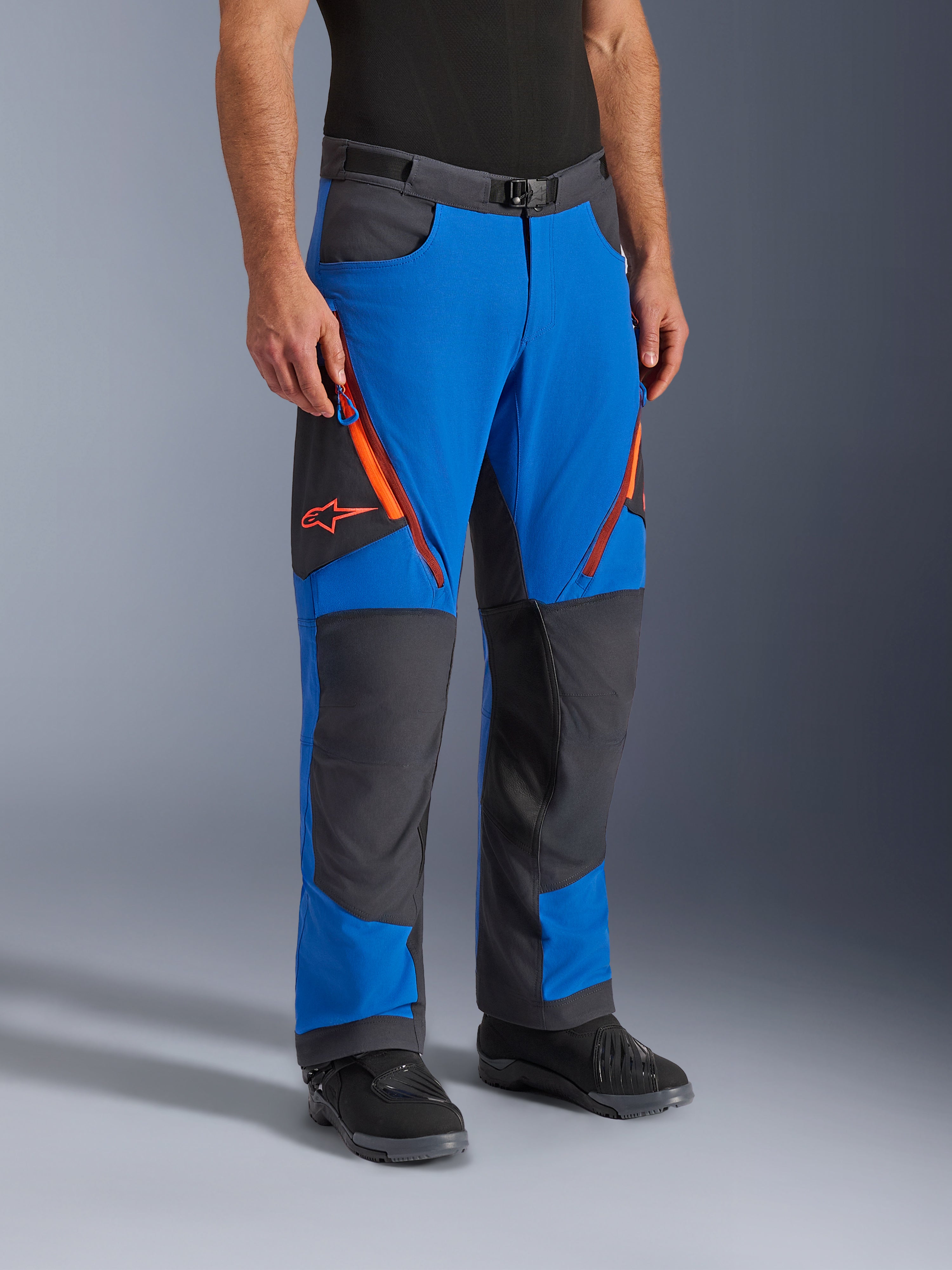 Alpinestars Maxdura Dual Pants, pantalon de moto d'aventure, bleu royal et gris foncé avec accents orange, doté d'aérations zippées aux cuisses, de panneaux renforcés aux genoux et d'une ceinture à boucle magnétique, conception technique par-dessus la botte pour la pratique du dual-sport.