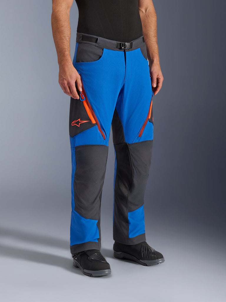 Alpinestars Maxdura Dual Pants, pantalon de moto d'aventure, bleu royal et gris foncé avec accents orange, doté d'aérations zippées aux cuisses, de panneaux renforcés aux genoux et d'une ceinture à boucle magnétique, conception technique par-dessus la botte pour la pratique du dual-sport.