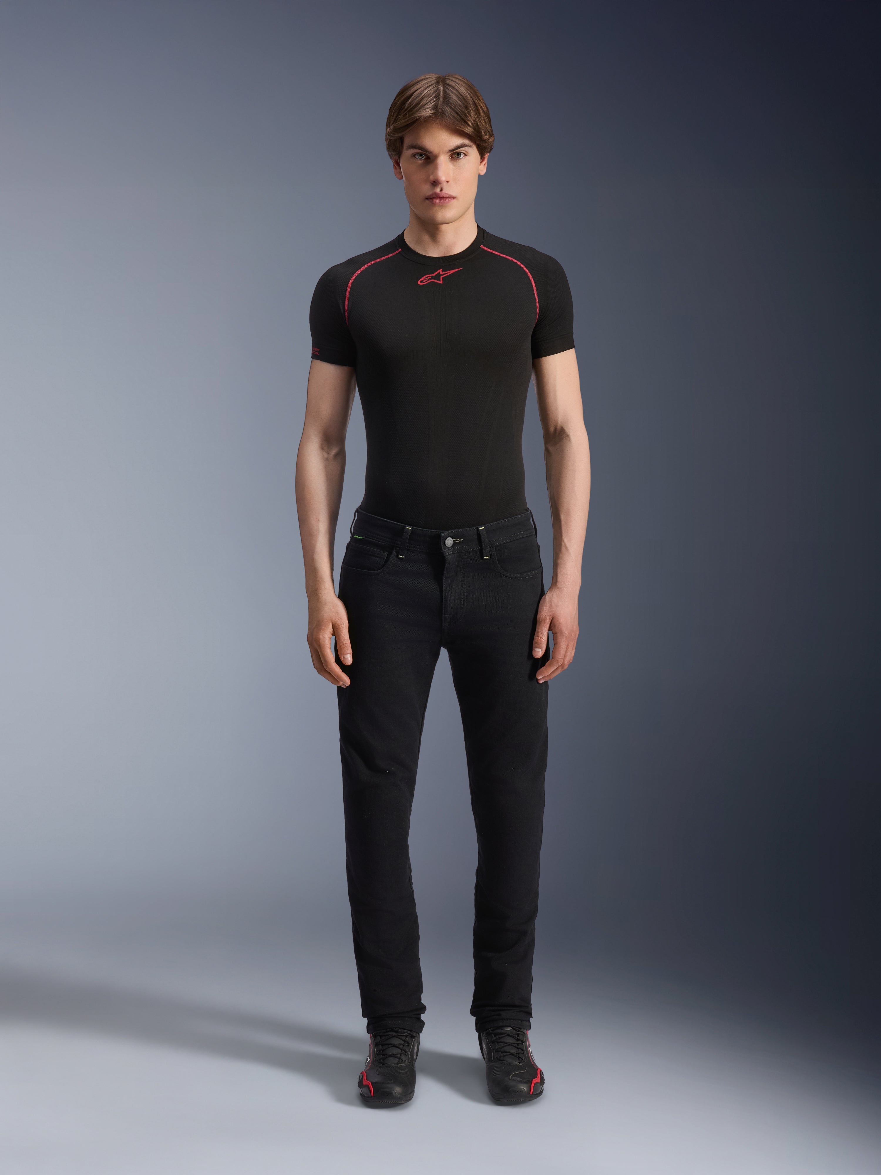 Alpinestars Copper V3 Denim Pants in Black Rinse, regular comfort straight-leg fit, worn by a male model with a black base layer t-shirt featuring red contrast stitching and black riding sneakers, urban motorcycle apparel ensemble