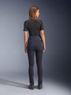 Alpinestars Stella Flex-AST Leggings noir, pantalon de moto taille haute pour femme, vue de dos montrant la coupe skinny et les poches arrière, porté avec un haut noir à manches courtes et des bottes de moto, équipement de conduite urbaine