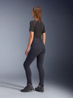 Leggings femme Alpinestars Stella Flex-Ast, noir, vue arrière montrant la coupe taille haute et les poches arrière, porté avec une sous-couche noire à manches courtes avec des touches de rouge et des chaussures de moto noires, équipement de moto urbain contemporain