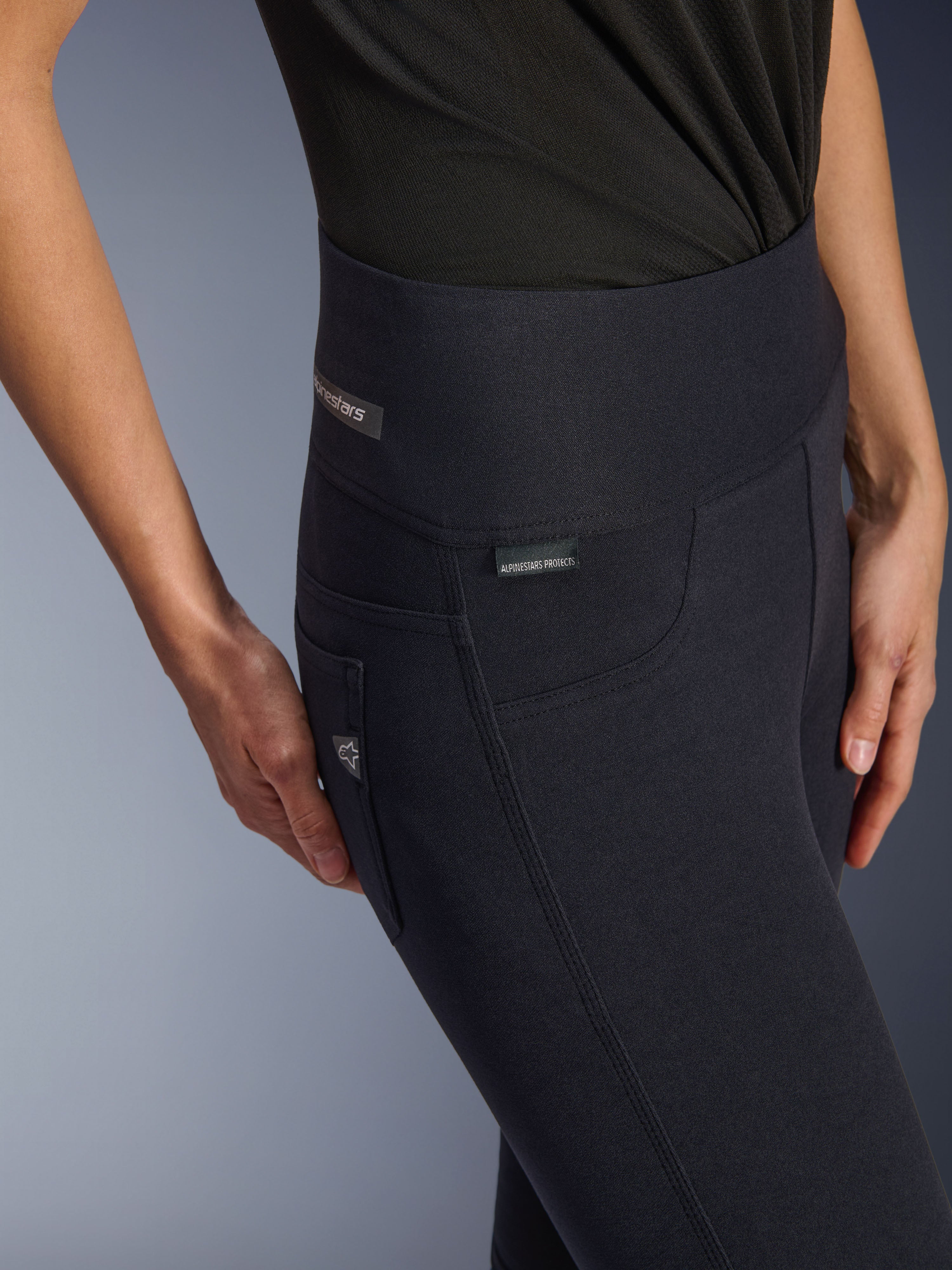 Leggings Alpinestars Stella Flex-AST pour femme, pantalon de moto noir à taille haute, gros plan sur la zone de la hanche présentant l'étiquette jacquard, coutures latérales à triple surpiqûre et détails de poche inspirés du denim, vêtement de conduite urbaine pour femme