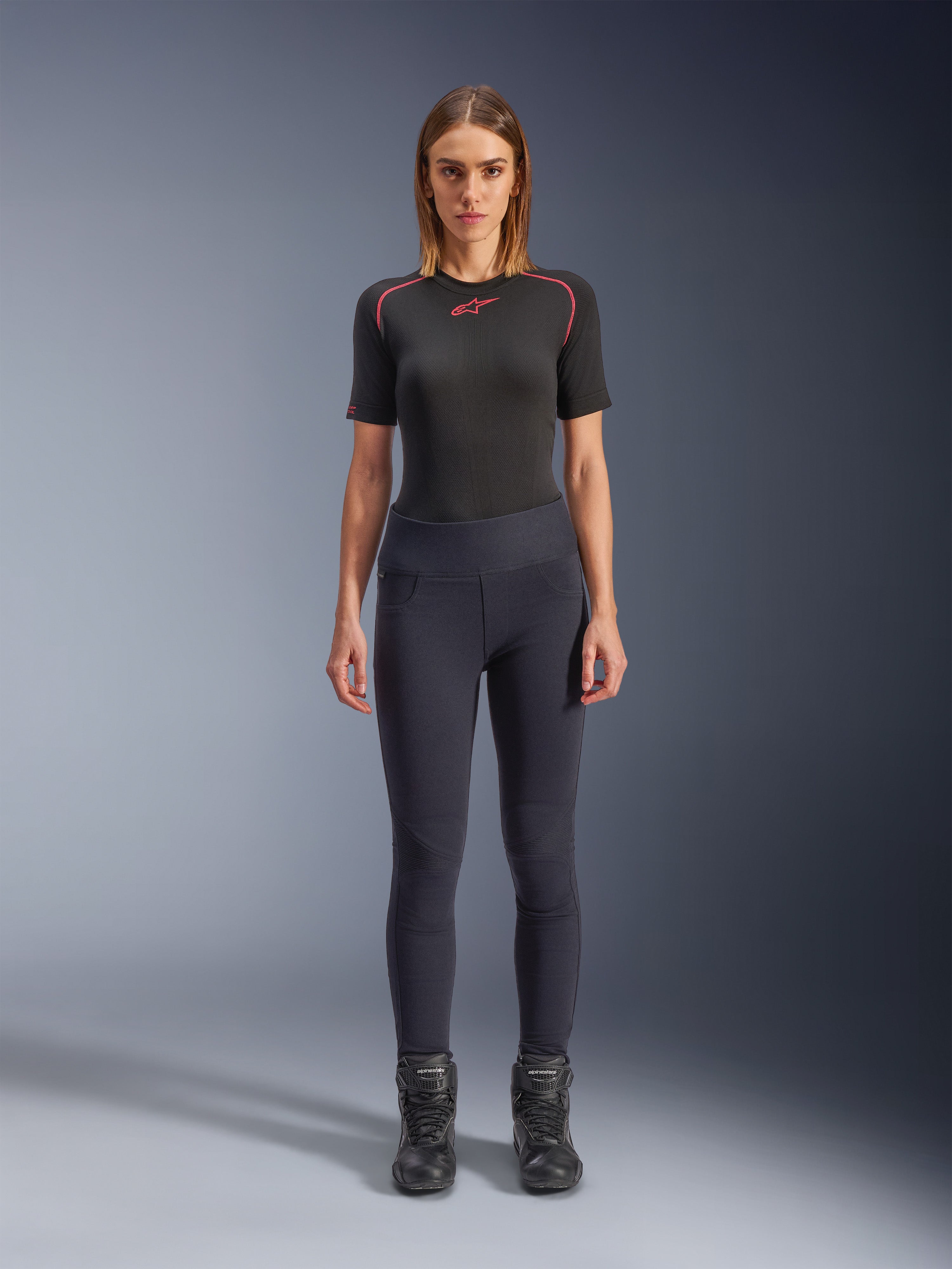 Leggings Alpinestars Stella Flex-Ast, leggings de moto pour femme, noir, portés avec un haut à manches courtes noir aux détails rouges et des bottes de moto noires, équipement de moto urbain contemporain à coupe ajustée, vue de face
