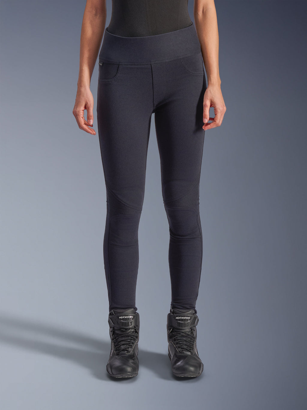 Alpinestars Stella Flex-Ast Leggings, leggings de moto pour femme, noir, coupe taille haute avec panneaux articulés aux genoux et coutures profilées, portés par un mannequin avec des bottes de moto noires, tenue de moto urbaine haute performance
