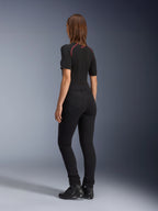 Leggings Banshee Femme Alpinestars, noir, vue arrière montrant la coupe anatomique extensible et les poches arrière, porté avec un haut noir à manches courtes et des bottes de moto, équipement de moto urbain élégant pour femme