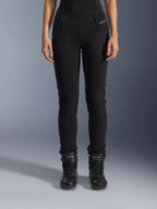 Alpinestars Womens Banshee Leggings, pantalon de moto noir, coupe ajustée avec empiècements en accordéon aux genoux, porté avec des bottes de moto montantes noires, équipement de route urbain au style décontracté