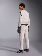 Alpinestars GP Race V3 Suit FIA, combinaison de course Argent Anthracite, vue de profil et de dos, portée avec des gants et des bottines de course noirs, avec des détails gris foncé à la taille et aux épaules, équipement de protection professionnel pour la course automobile.