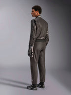 Alpinestars GP Race V3 Suit FIA, combinaison de course automobile noire avec des accents argentés, portée par un mannequin en vue de trois-quarts arrière, associée à des gants et des bottes de course noirs assortis, équipement de sport automobile professionnel présentant une conception élégante à deux couches.