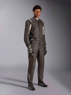 Pilote portant une combinaison Alpinestars GP Race V3 FIA, combinaison de course automobile noir et argent, avec gants et chaussures assortis, détails argentés sur les épaules et le bas des jambes, équipement de course automobile professionnel avec coupe ajustée