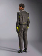 Rear view of the Alpinestars GP Race V3 Suit FIA, black with yellow fluo accents, worn with matching racing gloves and boots, professional auto racing gear featuring a two-layer aramidic construction