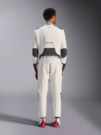 Vue arrière d'un mannequin portant la combinaison Alpinestars Hypertech V3 en Blanc Noir Argent, montrant le large panneau stretch lombaire noir avec les logos « alpinestars » et « RACING AHEAD », des inserts noirs aux coudes, l'étiquette d'homologation FIA sur le col, et une coupe athlétique slim conçue pour la course professionnelle.