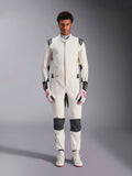 Combinaison Alpinestars Hypertech V3, combinaison de course automobile professionnelle, blanc, noir et argent, portée par un mannequin avec des gants rouges et blancs et des chaussures de course blanches assorties, avec des panneaux contrastés noirs et des logos Alpinestars, design à coupe slim athlétique