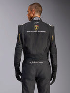 Vue arrière de la combinaison Alpinestars GP Tech V4 Édition Limitée Lamborghini, noire avec accents dorés, présentant l'écusson Automobili Lamborghini et le texte « SQUADRA CORSE » dans le dos, combinaison de course professionnelle certifiée FIA pour la compétition automobile