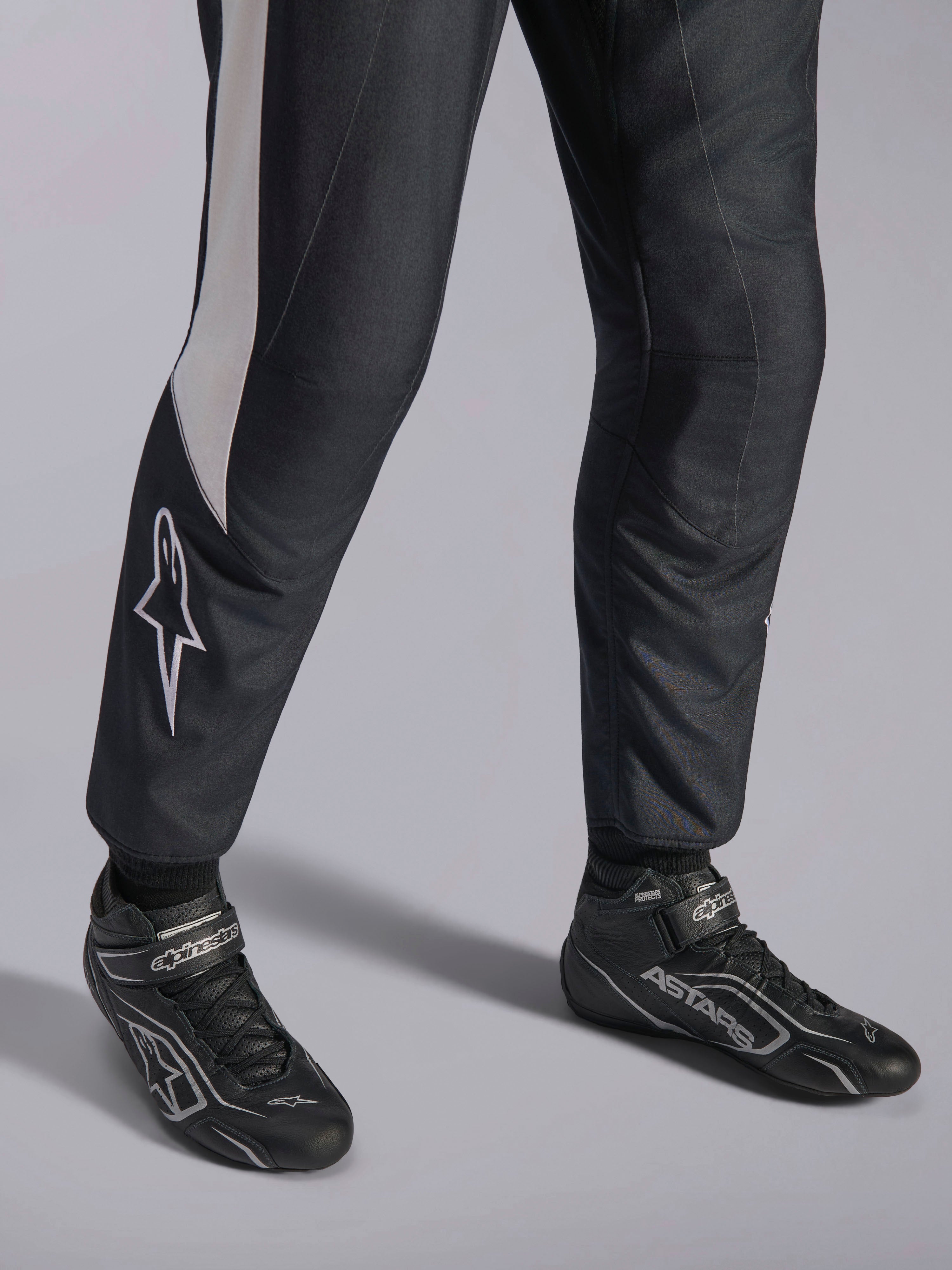 Combinaison Alpinestars GP Pro Comp V2 FIA, équipement auto noir et blanc et bottines de course professionnelles ASTARS.